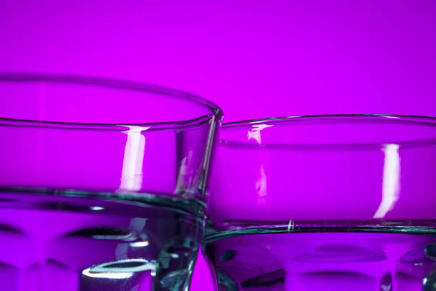 istock The water in two glassese on lilac background 933739064