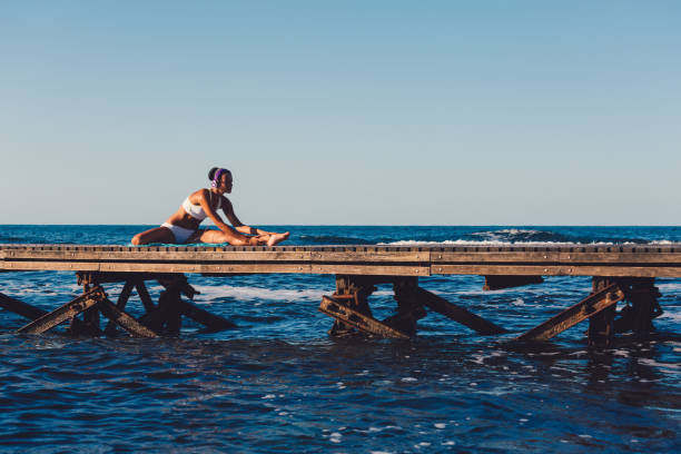 istock Sportswoman stretching at beach holiday 933743326