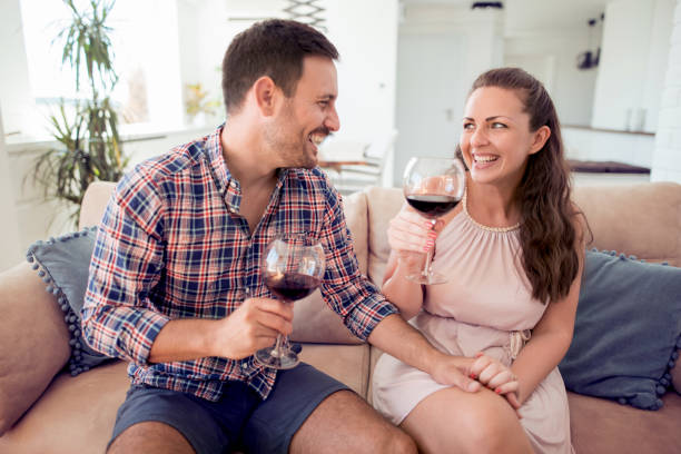 istock Young romantic couple sitting on sofa in living room 933763768