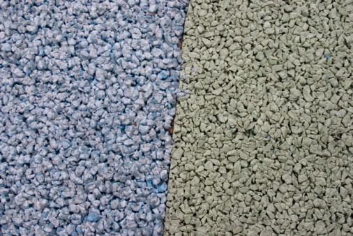 A  close-up of a green and blue foam-blown playground floor.  The two colors are separated by a clear line, possibly representing contrasts or antithetical ideas.