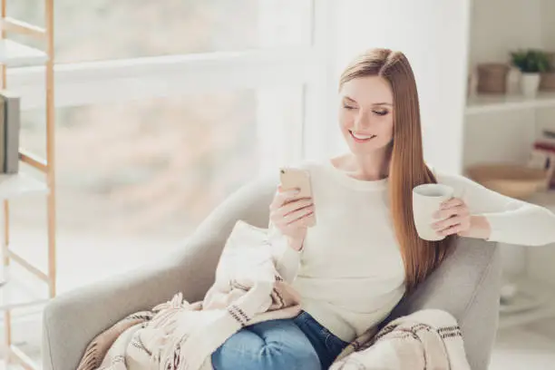 Vacation holiday funny teenager serenity white caucasian breakfast modern technology social-network girlish feminine concept. Cute tender lovely sweet girl browsing on the internet holding cup of tea