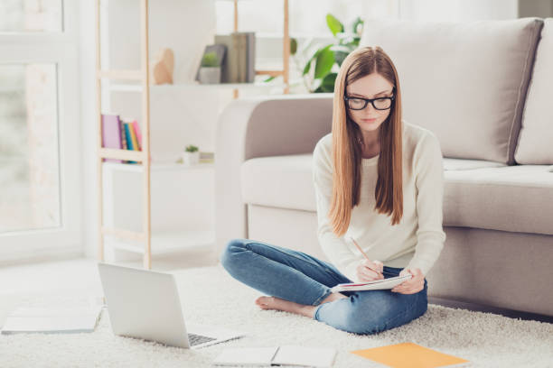 istock Academic campus degree brainstorming pupil highschool people concept. Concentrated focused cute clever thinking pondering pensive girl doing homework in house on the white fluffy carpet 933789930