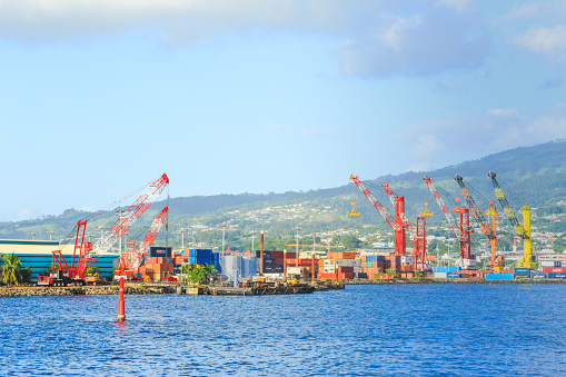 Papeete, French Polynesia – March 18, 2018 :  The big cranes and Containers at Large commercial port  in Tahiti PAPEETE, FRENCH POLYNESIA.
