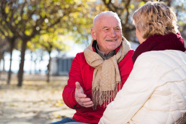 istock Mature couple talking in park 933801396
