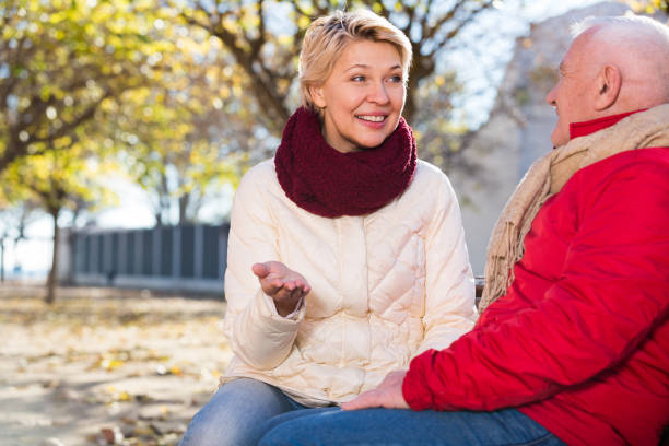 istock Mature couple talking in park 933801410