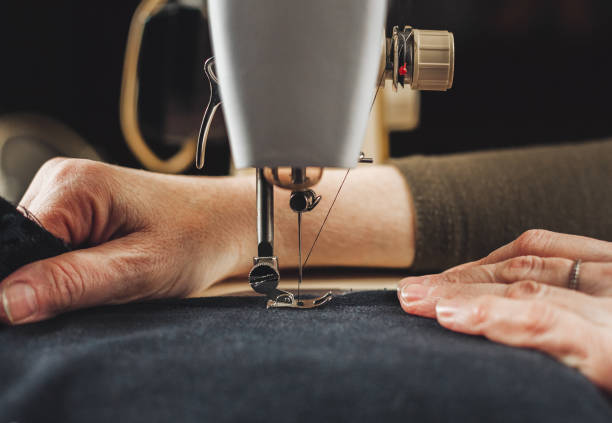 Female hands working with sewing machine stock photo