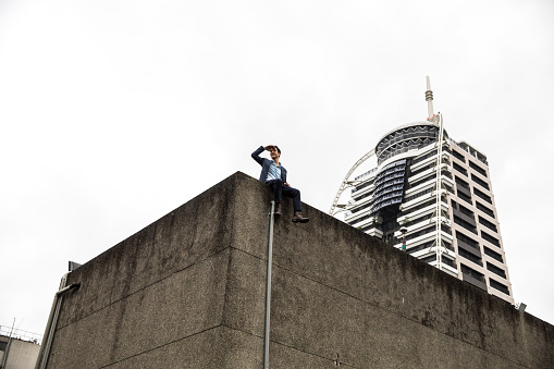 Smart business man on the top of the downtown buildings in Taipei, Taiwan.