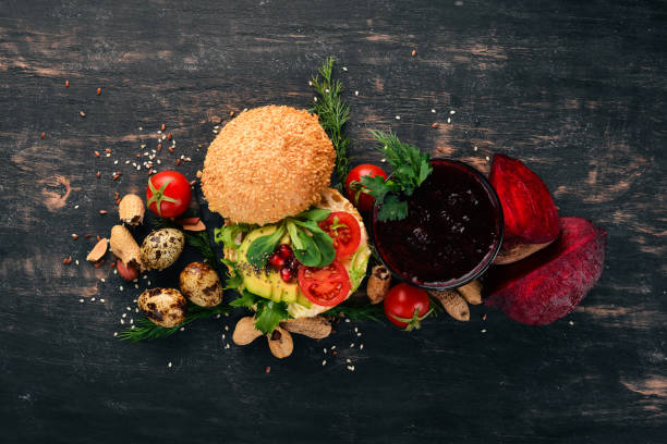 Breakfast. Beetroot juice and avocado burger and vegetables. On a wooden background. Top view. Copy space.