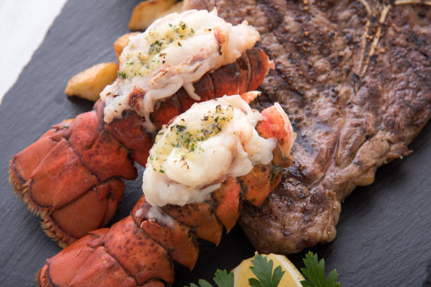 istock grilled lobster tail and T bone steak 933820684