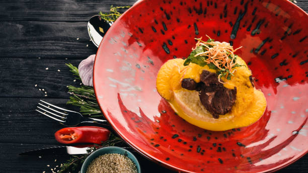istock Beef loin with mashed couscous. Hot appetizers. Top view. On a black wooden background. Copy space. 933826346