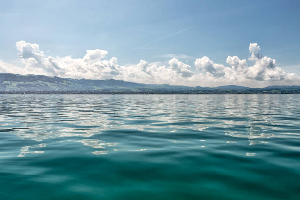 In the middle of Lake Constance with the view to the Swiss boarder on a sunny summerday. Standing on a sailboat. On the horizon you can recognize Mount Säntis and the hills from Appenzellerland.