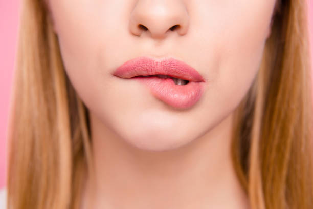 Fillers plump plastic herpes surgery concept. Close up cropped photo of big full natural with lipgloss lips teeth biting lips blonde hair hairstyle isolated on background Fillers plump plastic herpes surgery concept. Close up cropped photo of big full natural with lipgloss lips teeth biting lips blonde hair hairstyle isolated on background human sexual behavior stock pictures, royalty-free photos & images