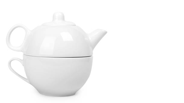 istock white ceramic kettle or teapot with cup. Isolated on white background. copy space, template 933856358