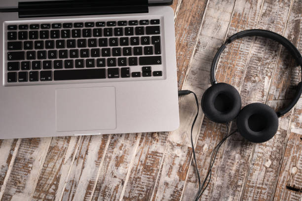 istock Headphones and laptop  on wood background 933856912