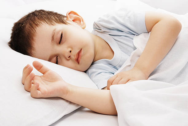istock A little boy with brown hair fast asleep in a bed 93386366