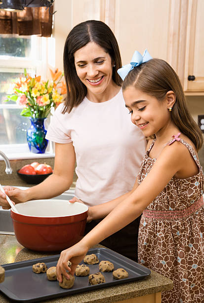 A picture of a mother and daughter baking cookies stock photo