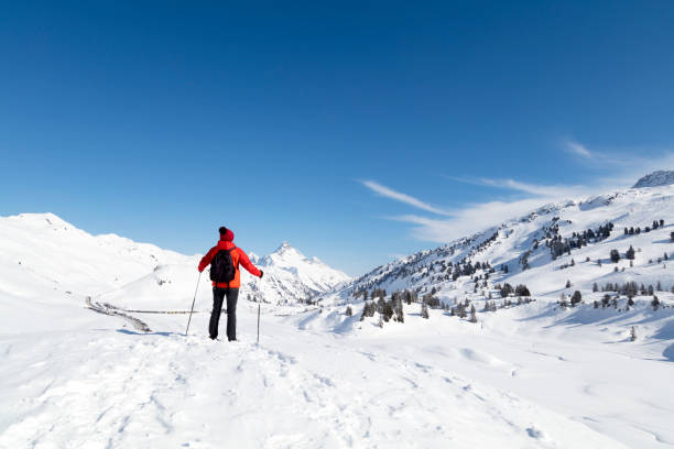 istock Woman with ski poles on snowy mountain 933877774