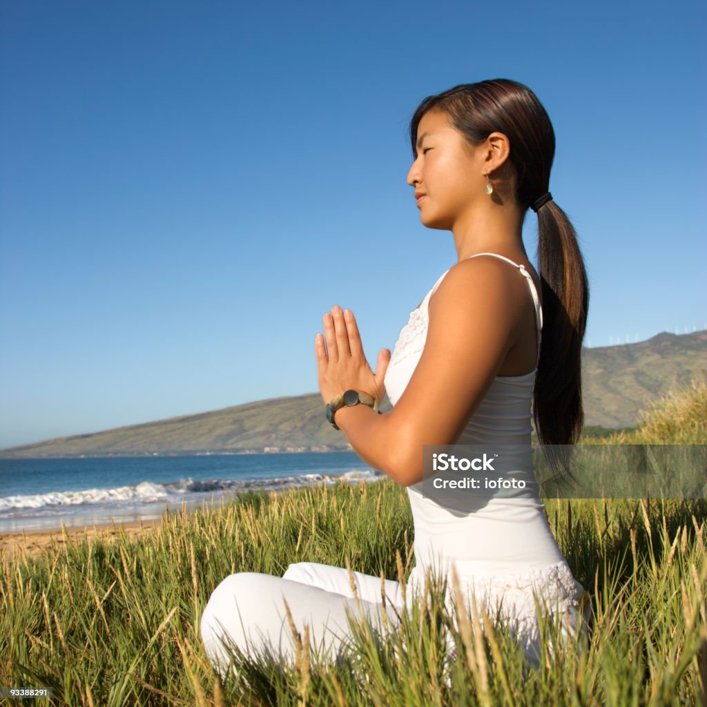 Donna seduta meditare all'aperto - Foto stock royalty-free di 25-29 anni