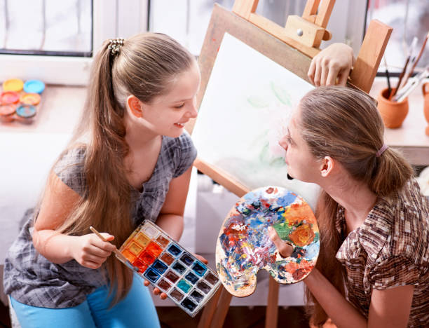 istock Artist painting on easel in studio. Authentic children paints . 933883202