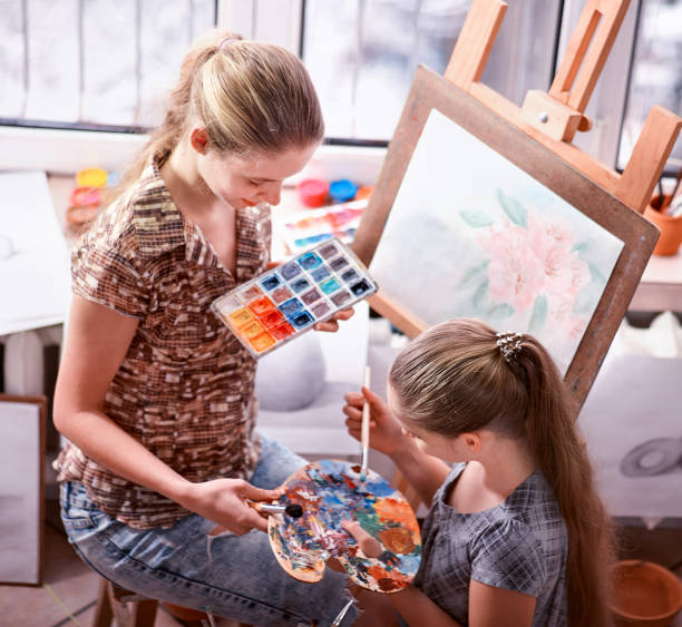 istock Artist painting on easel in studio. Authentic children paints . 933883210