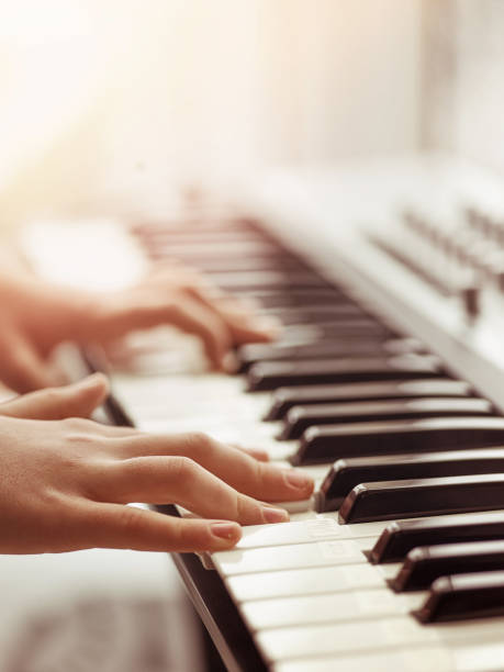 istock Midi keyboard or electronic piano and playing child hands. 933883358