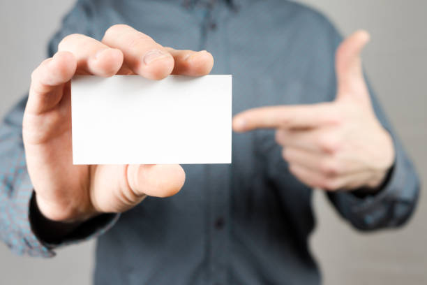 istock Businessman holding a business card. Mock up. Copy space. 933885974