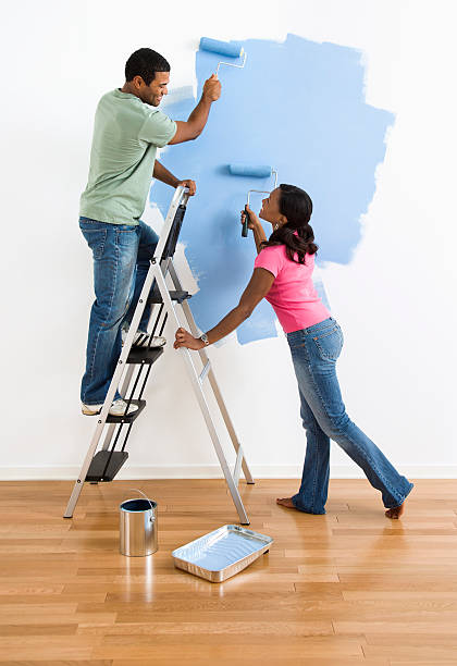 Couple painting wall blue. stock photo