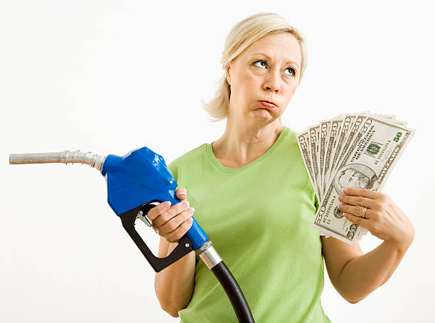 infelice donna con gas pompa e denaro. - gasoline fuel pump women currency foto e immagini stock