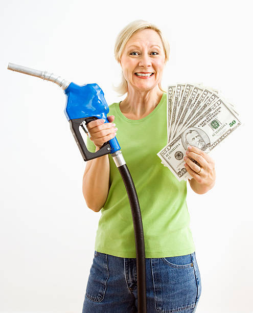 donna felice con gas pompa e denaro. - gasoline fuel pump women currency foto e immagini stock