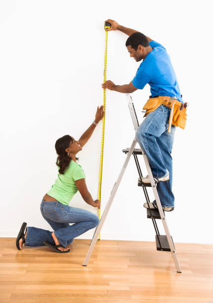 Couple measuring wall. stock photo