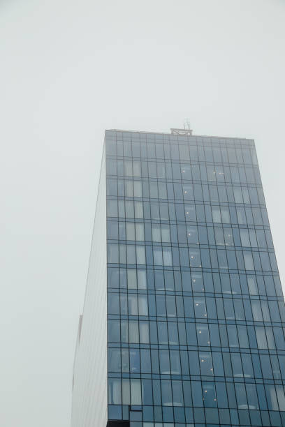 istock Modern glass building on foggy sky background, bottom view 933891380