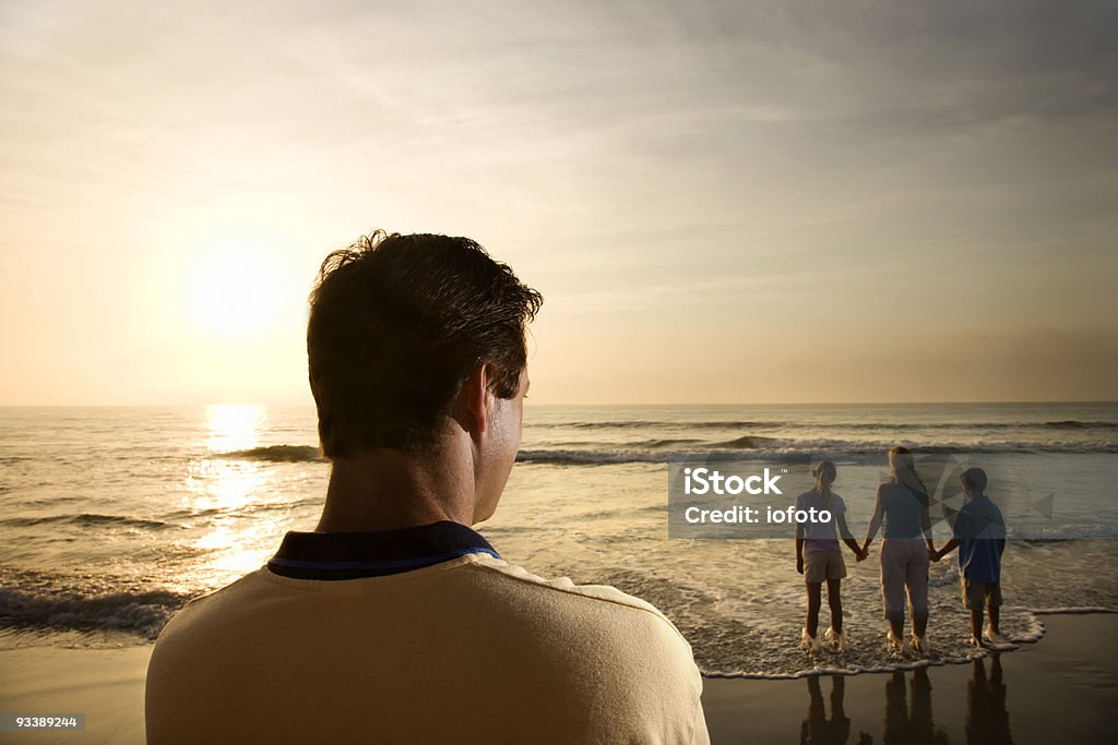 Homme regardant votre famille à la plage - Photo de Famille libre de droits