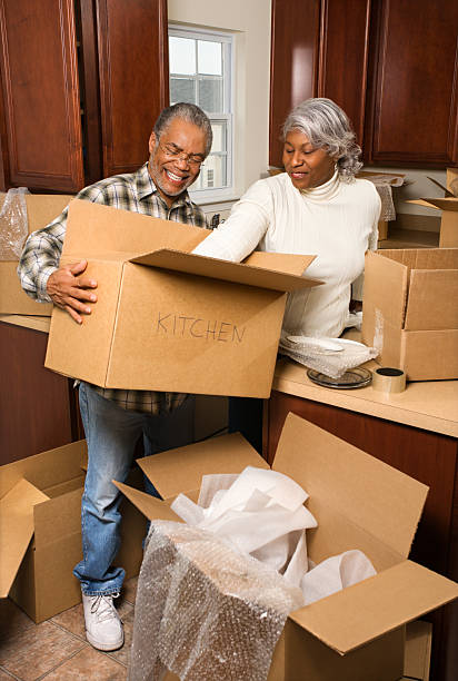 Middle-aged couple unpacking boxes. stock photo