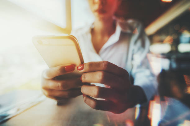 Female hands holding cellphone in a restaurant