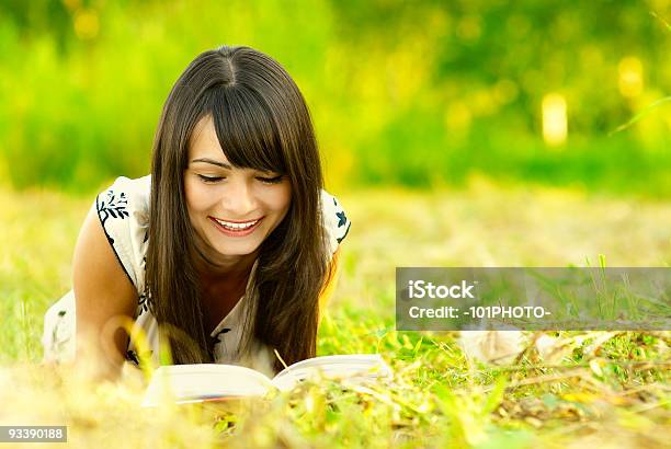 Girl Reads Book On Meadow Stock Photo - Download Image Now - Adolescence, Adult, Agricultural Field