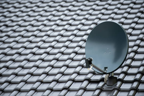 satellite dish on a new black roof stock photo
