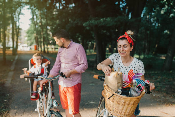 istock Young family eating breadsticks while riding bicycles in the park 933909356