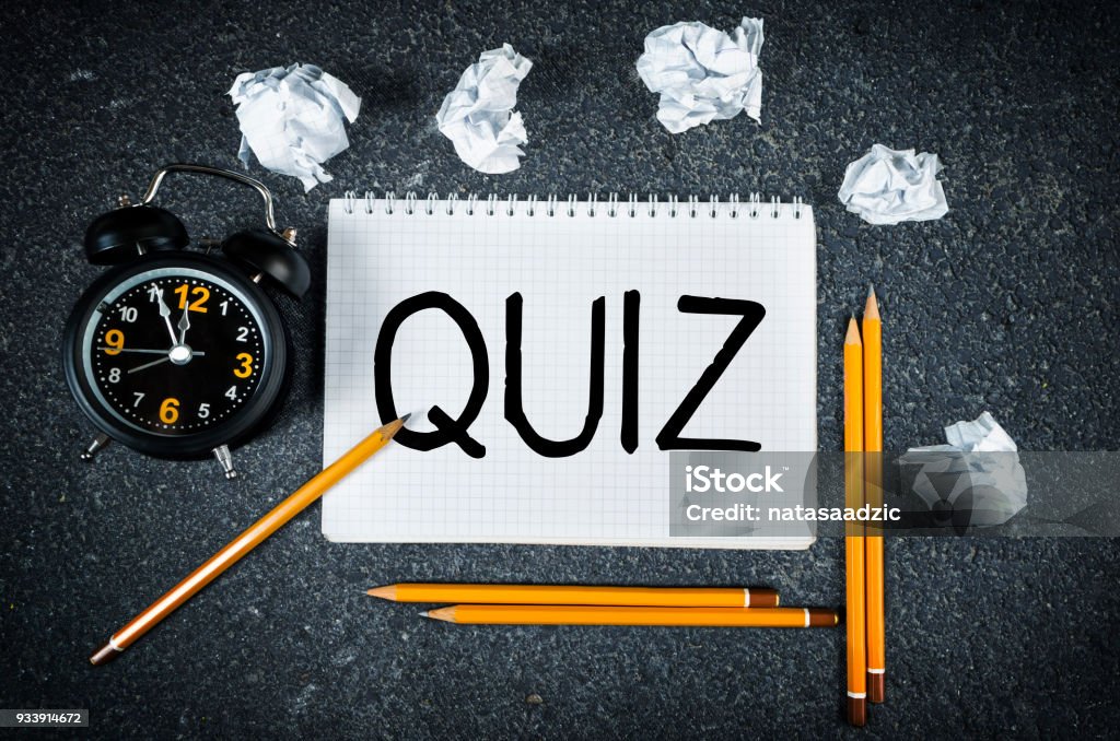 Quiz Quiz handwritten on paper top view with pencils, clock and crumpled paper. Question Mark Stock Photo