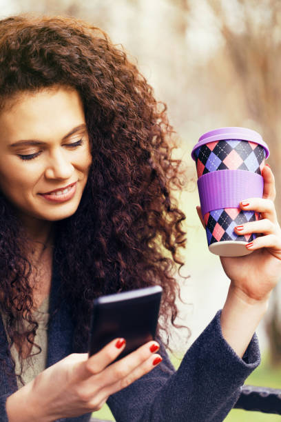 istock Beautiful businesswoman texting and drinking coffee 933917242