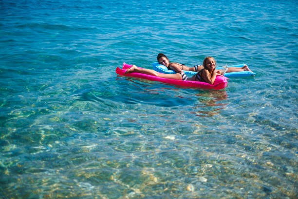 istock Mother and daughter floating on air beds and posing 933917296