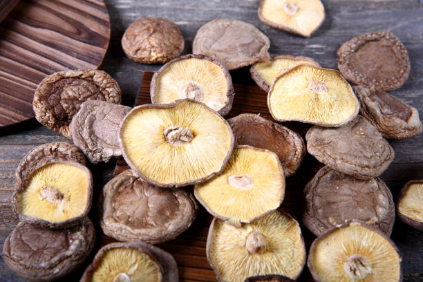 shiitake-pilz auf holztisch - shiitake mushroom edible mushroom mushroom dry stock-fotos und bilder