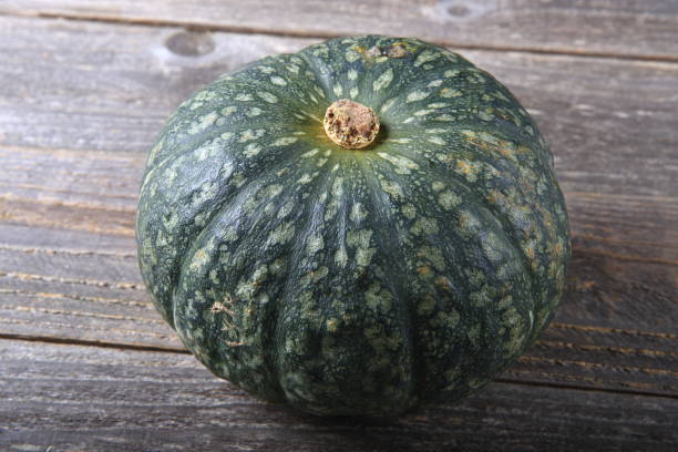 istock Green pumpkin on a wooden table 933929754