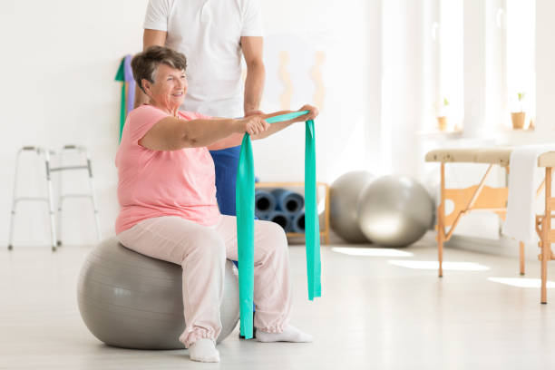 istock Elderly woman sitting on ball 933940056
