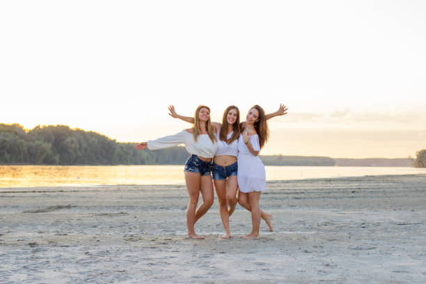 istock Three beautiful girls on the sandy beach 933948934