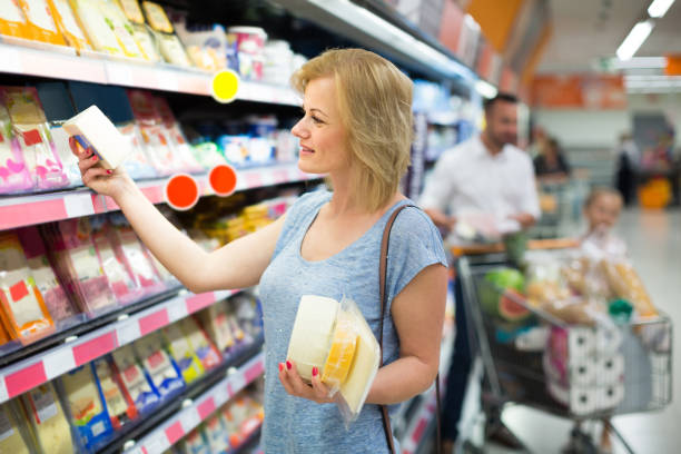 portret kobiety trzymającej asortyment sera w sklepie spożywczym - three different refrigerators zdjęcia i obrazy z banku zdjęć