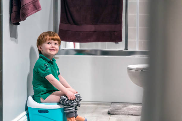 Happy Cute Redhead Little Boy Potty Training Happy Cute Redhead Little Boy Sitting on Potty Trainer potty toilet child bathroom stock pictures, royalty-free photos & images