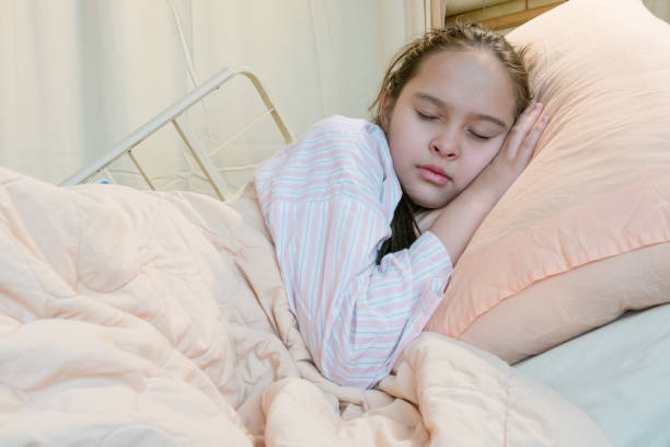 istock Mixed race tween girl in hospital bed 933972404
