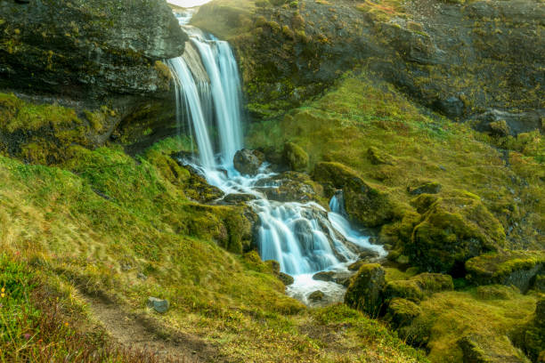 istock Long exposure of a small waterfall running through a green moss valley in Iceland 934003466