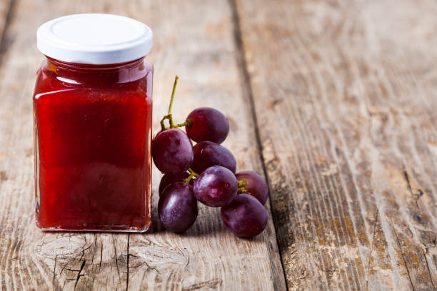 Jar of  jam and grapes on a wooden background. Delicious dessert.
