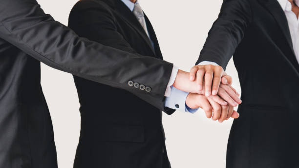 Businessmen joining hands together in the concept of team work and cooperation isolated on white background with clipping path stock photo